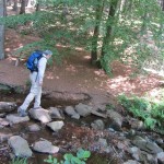 Easy Hiker crossing by stones on hiking trail in Germany "Easy Hiker crossing by stones on Saar-Hunsruecksteig hiking trail in Germany"